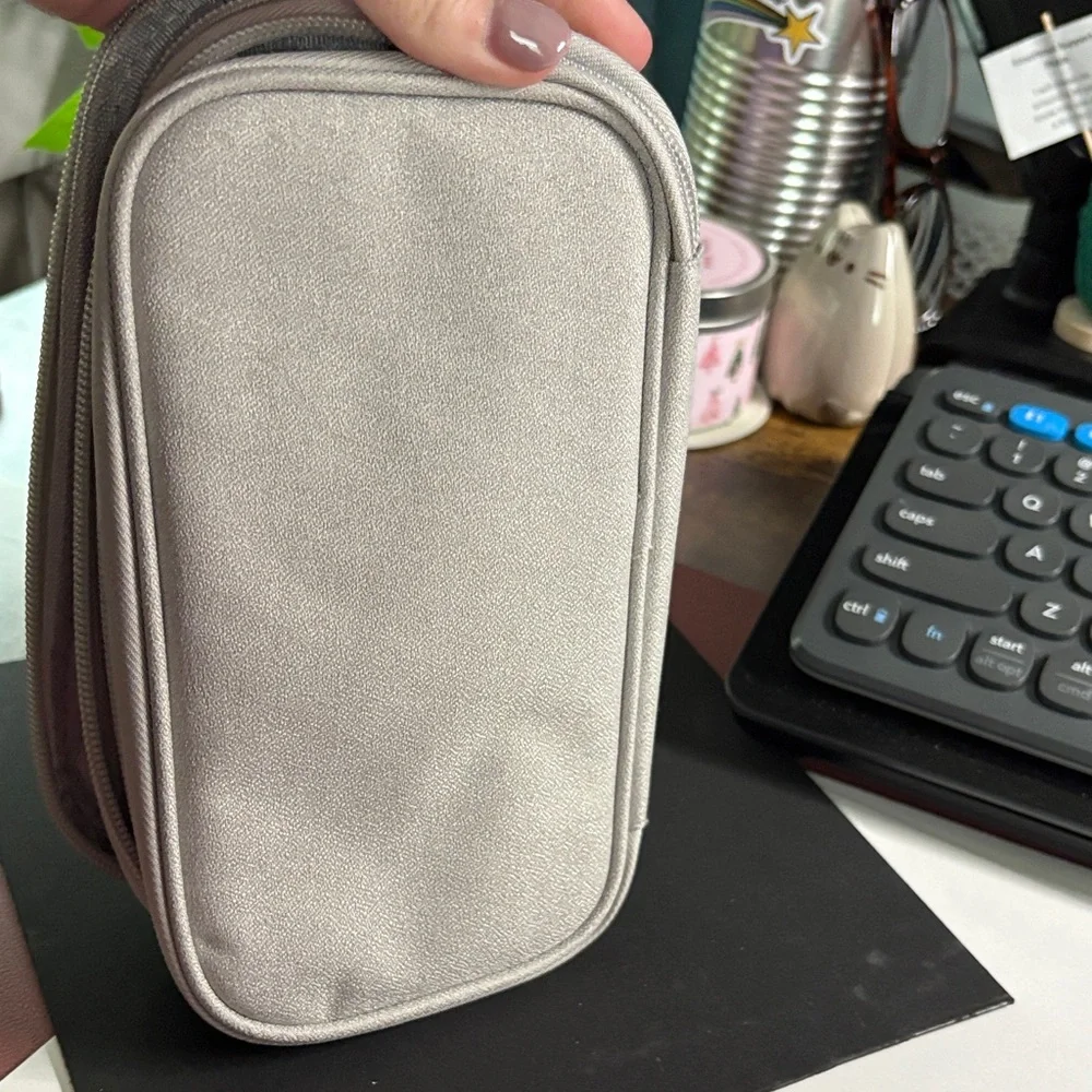 Silver Travel Bag for Charger, Plugs, and Earbuds.
